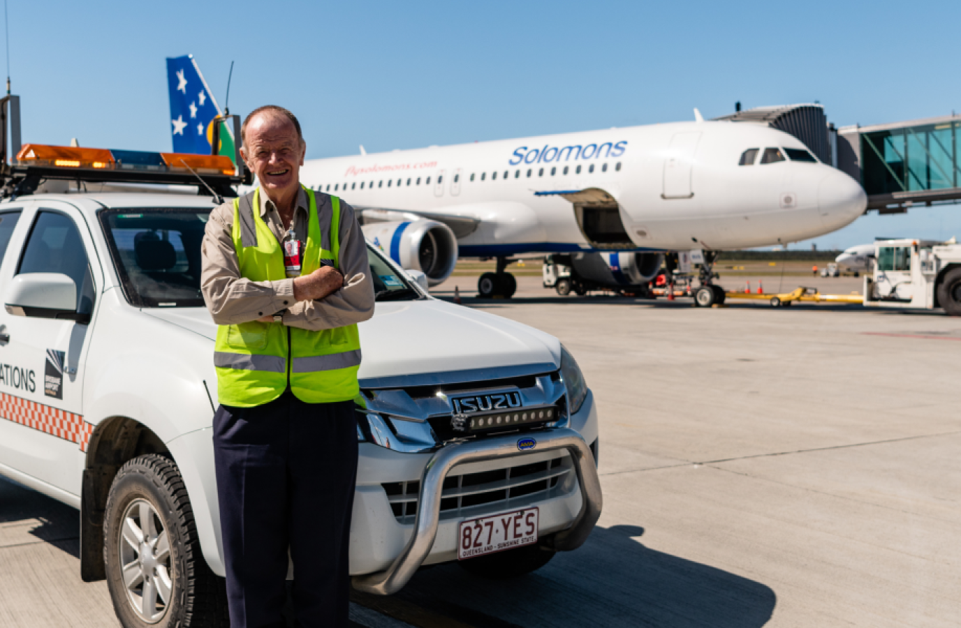 Airport staff leaning on a vehicle near to aeroplane