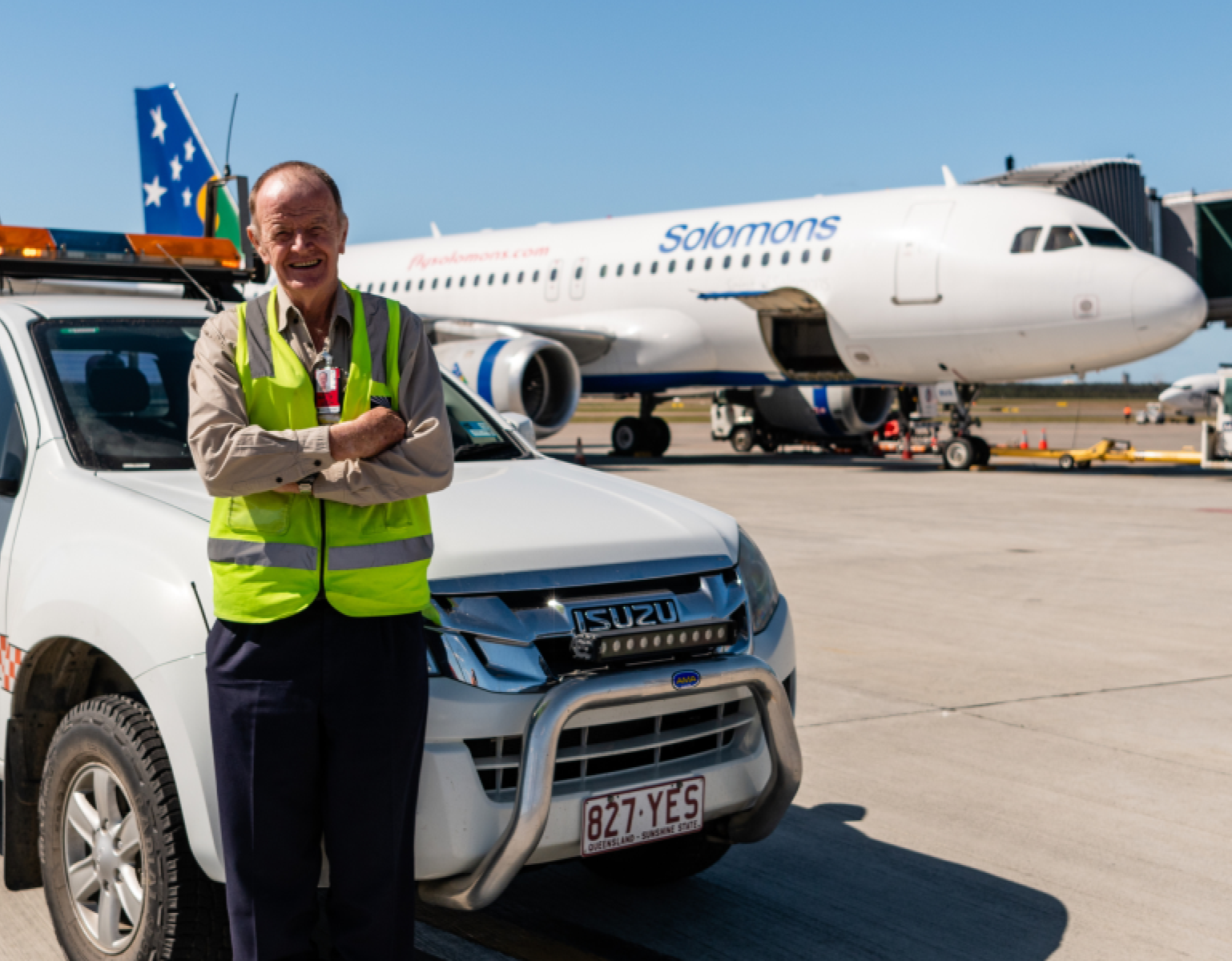 Airport staff leaning on a vehicle near to aeroplane